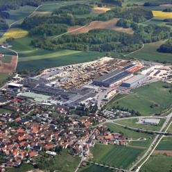 SchwörerHaus in Oberstetten in der Nähe von Münsingen im Biosphärengebiet Schwäbische Alb. Ein Luftbild eines kleinen Orts mit einem großen Industriegebiet.