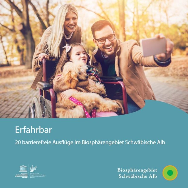 Das Biosphärengebiet Schwäbische Alb barrierefrei erleben. Das Cover der Broschüre erfahrbar. Zwei Erwachsene stehen um einen Rollstuhl in dem ein Kind sitzt, das einen Hund auf dem Schoß hat. Sie lächeln und machen ein Selfie mit dem Handy.