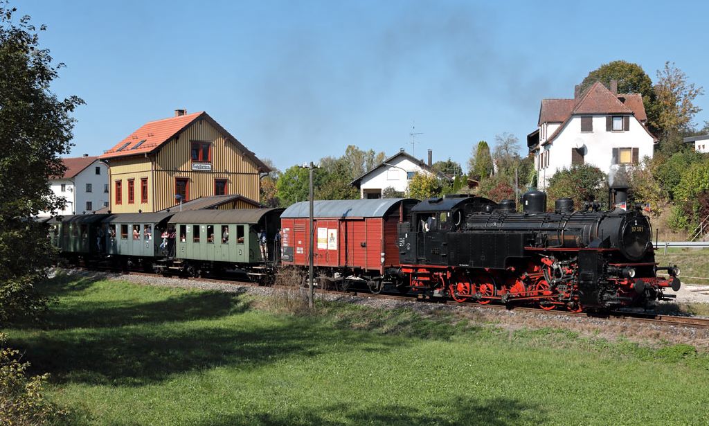 Dampfzugfahrten in Münsingen ist ein perfekter Ausflugstipp im Biosphärengebiet Schwäbische Alb. Eine Dampflok zieht mehrere Waggons über Schienen durch die Landschaft der Schwäbischen Alb.